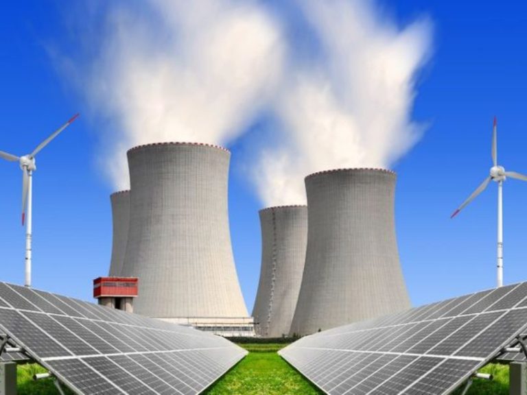 15688416 – solar energy panels before a nuclear power plant and wind turbines